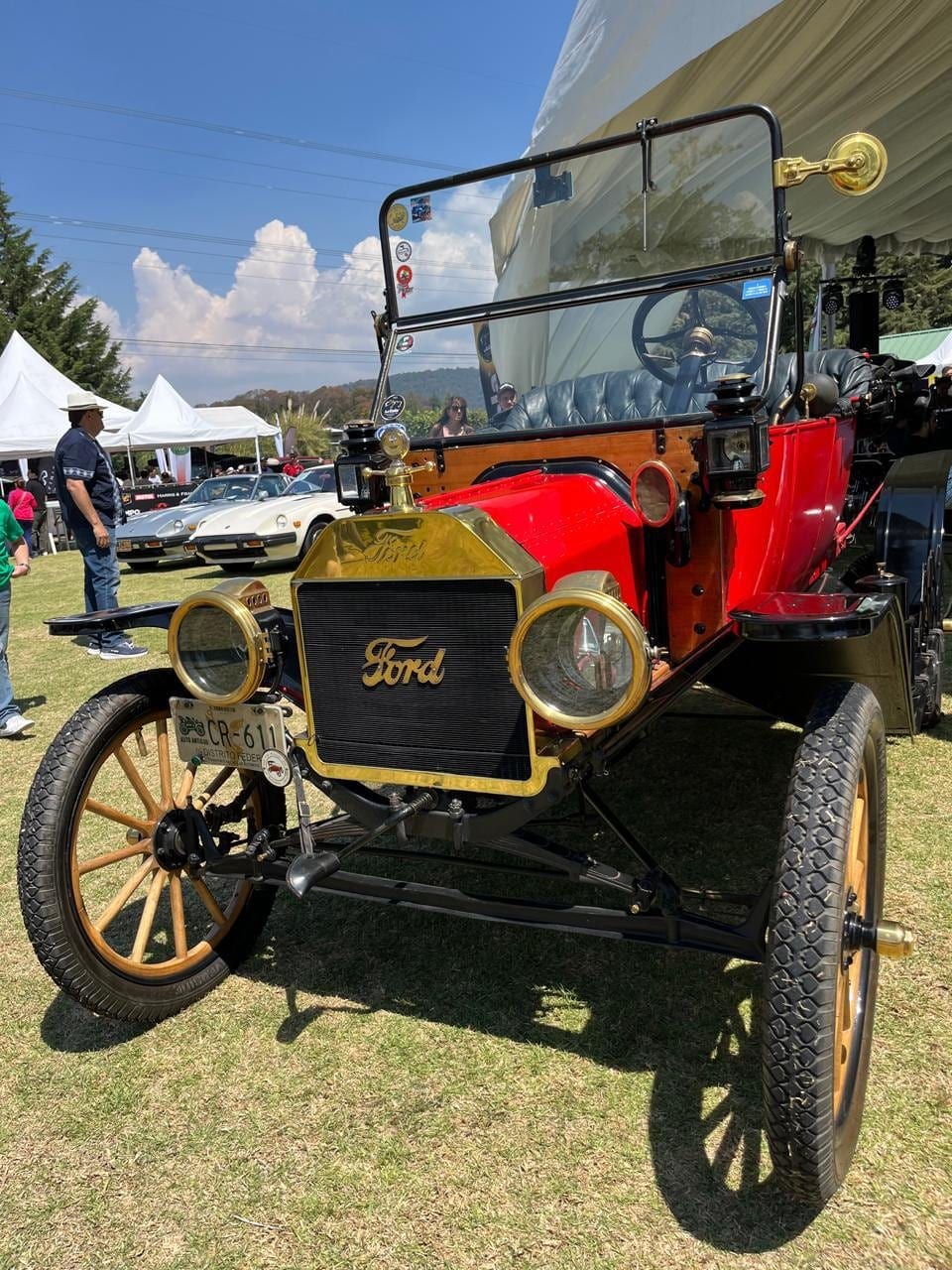 Ford Modelo T rojo con llantas de rayos de madera, en exhibición.